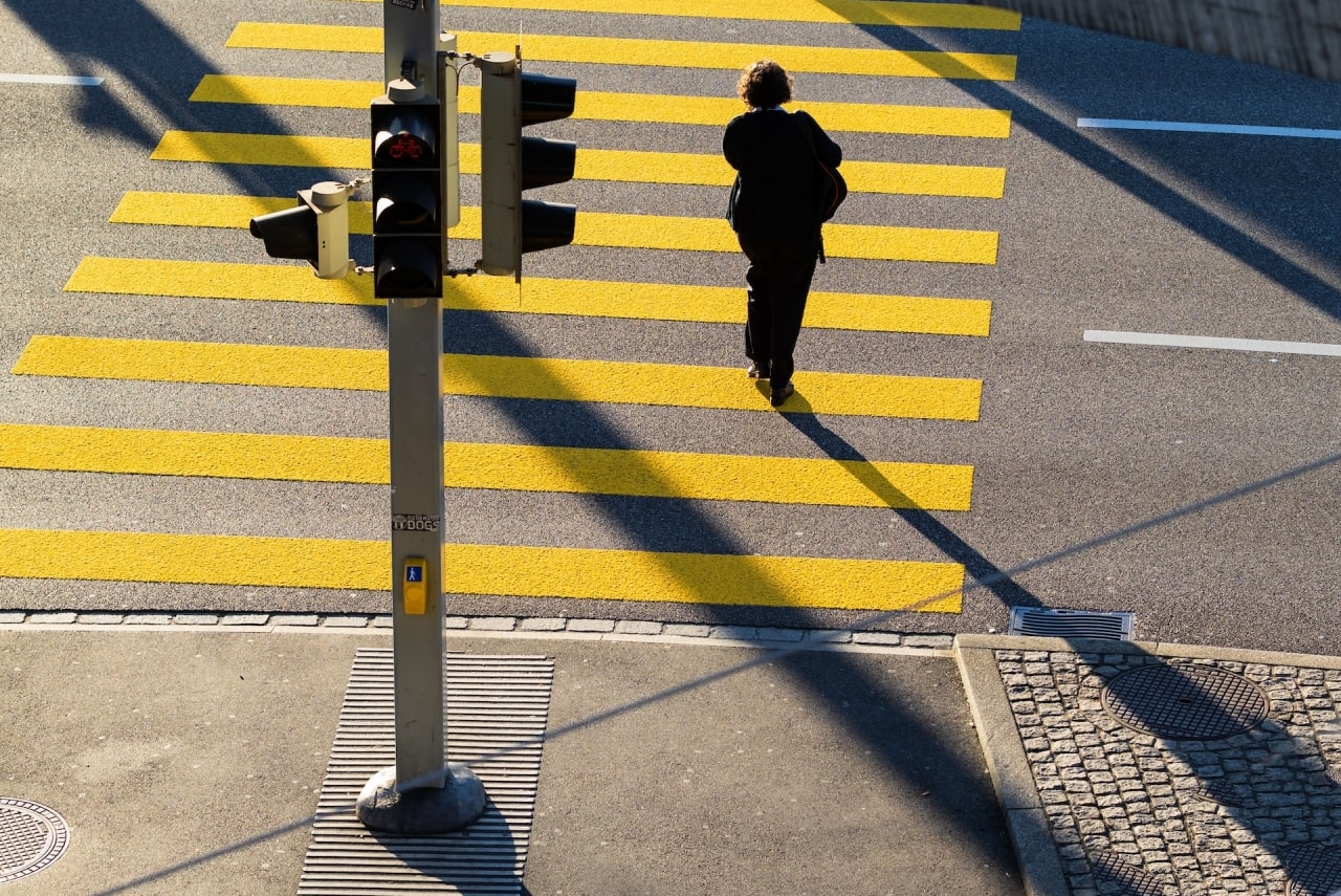 Rancho Cucamonga woman wearing black clothing crossing street in marked pedestrian crosswalk